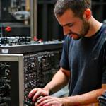 Retrato de Carlos Gómez, técnico de estudio, configurando equipos de audio con precisión.